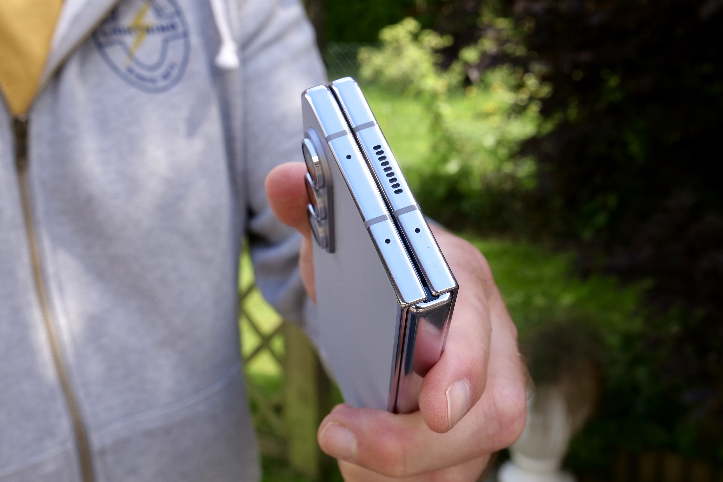 A person holding the Samsung Galaxy Z Fold 5, showing the top of the hinge.