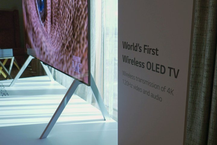 Profile view of the sligm LG M-Series OLED TV next to promotional material at CES. 