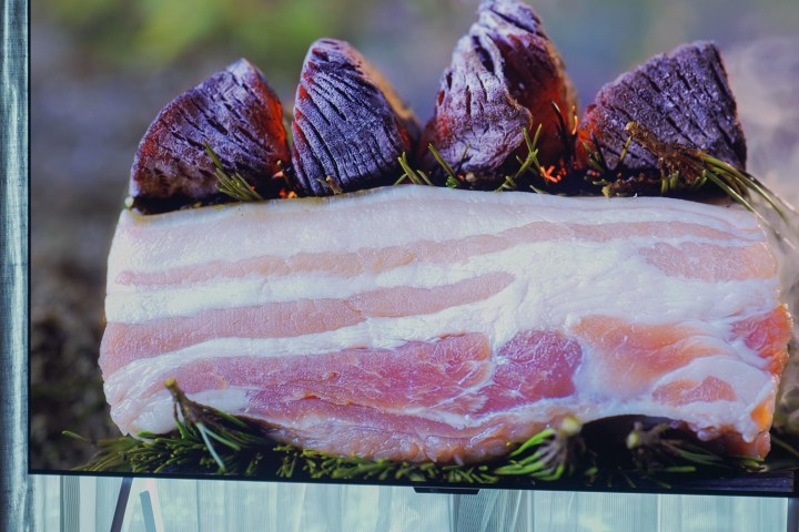 Close up of slab bacon on a bed of rosemary displayed on an LG M-Series OLED.