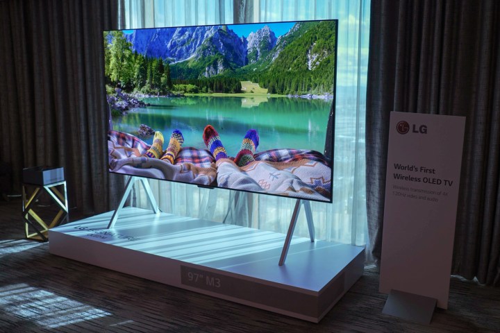 Feel clad in colorful cozy wool socks at the end of a bed that looks out over a fjord displayed on an LG M-Series OLED.
