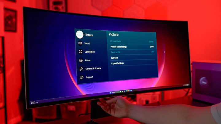 A hand controlling the Samsung Odyssey OLED G8.