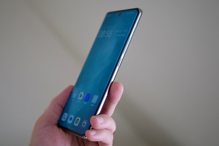A person holding the Oppo Reno10, and showing the side of the phone.