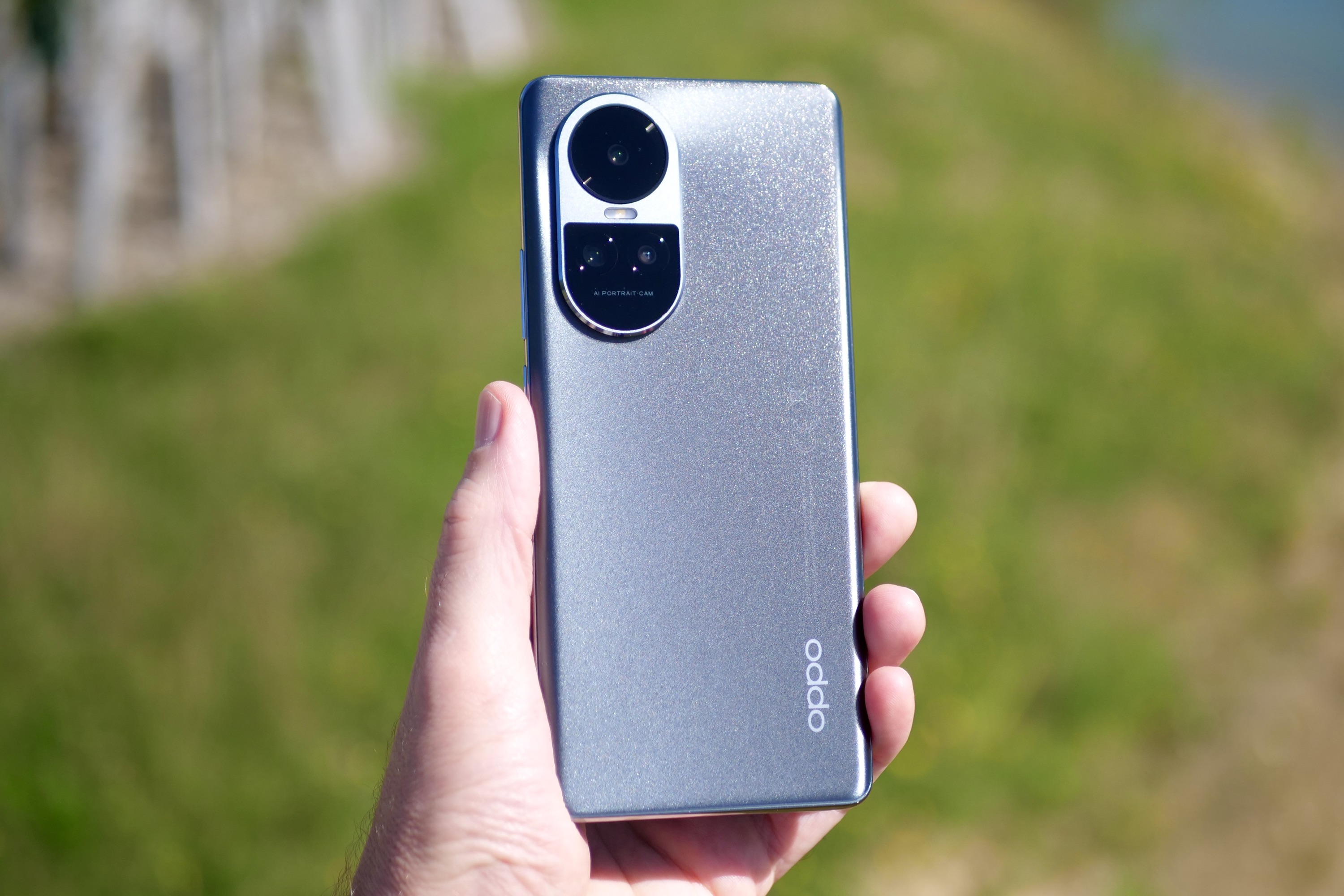 A person holding the Oppo Reno10, showing the back of the phone.