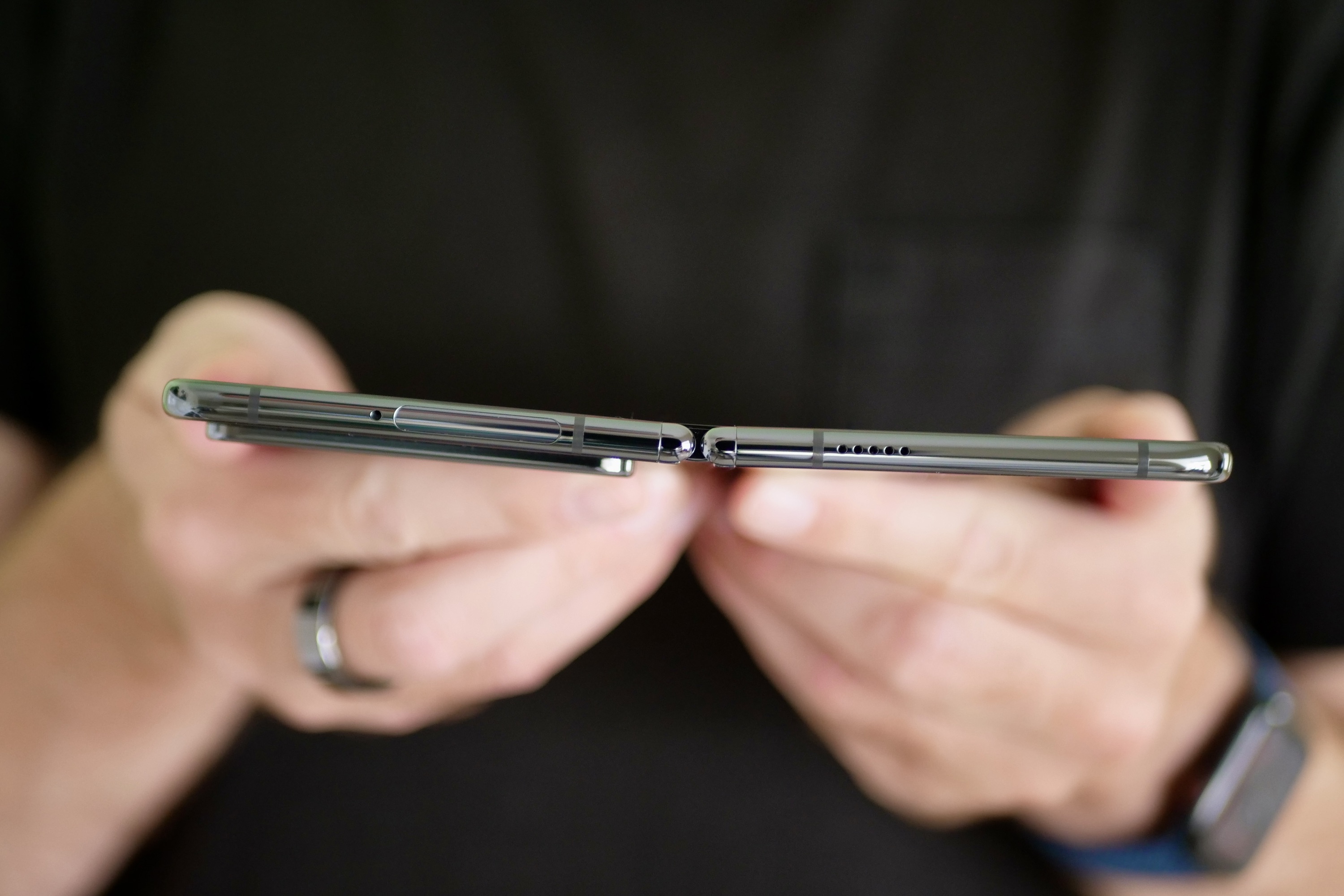A person holding the Google Pixel Fold showing how it doesn't fold flat.