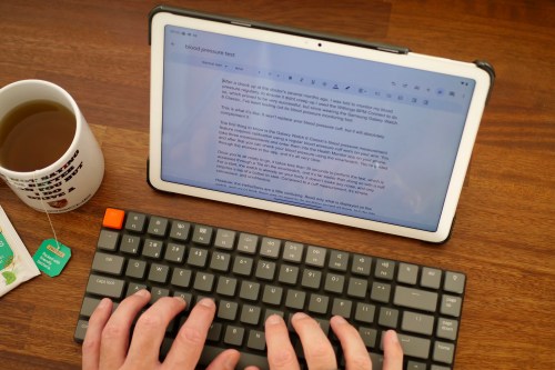 A person typing on a keyboard, connected to a Pixel Tablet.