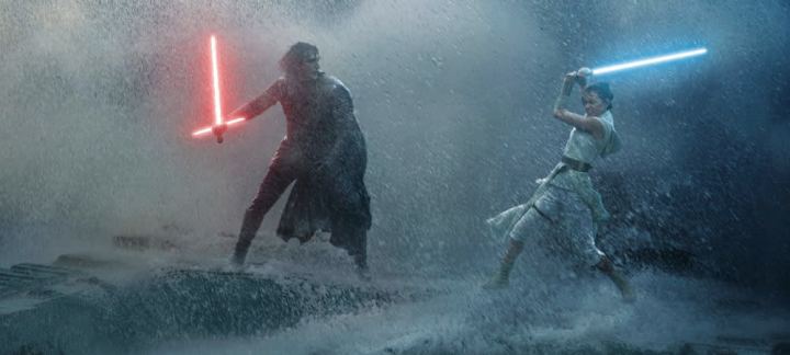 Rey and Kylo Ren swing their lightsabers on the wreckage of Death Star II as waves crash behind them.