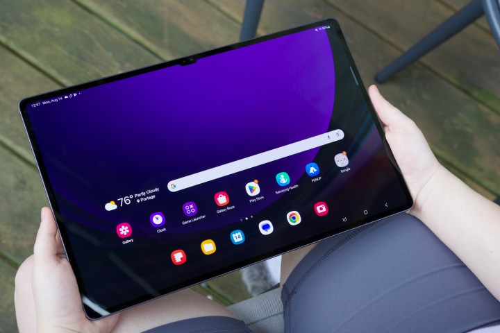 Someone holding the Samsung Galaxy Tab S9 Ultra with its display on.