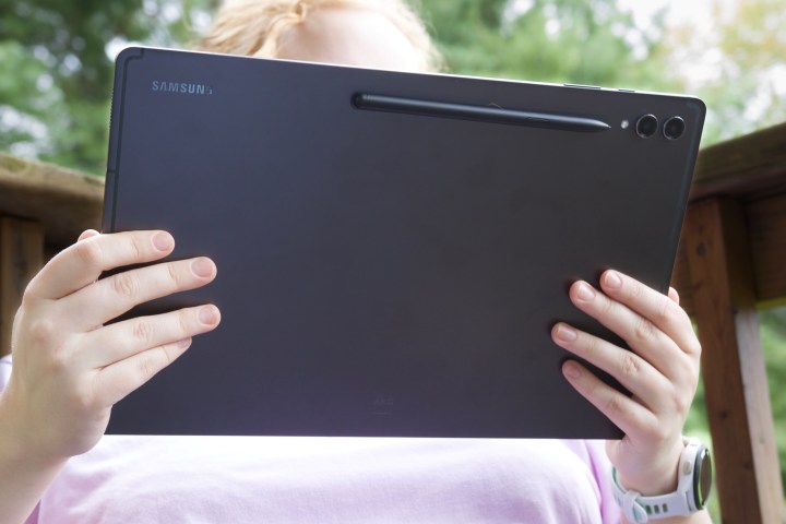 The back of the Samsung Galaxy Tab S9 Ultra, seen with someone holding it outside.