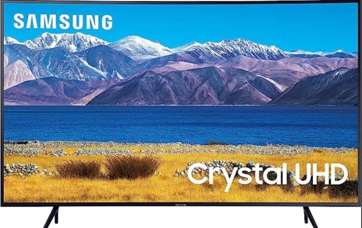 Uma TV Samsung exibe uma cena de lago e montanha.