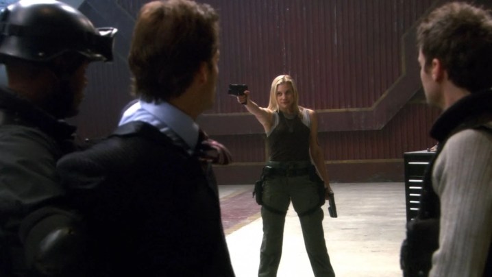 Kara Thrace aims a gun at mutineers in the Battlestar Galactica episode "The Oath"