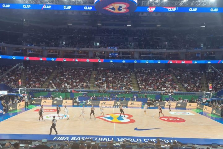 Players on a basketball court in the FIBA World Cup.