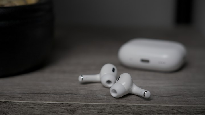 USB-C और MagSafe बड्स के साथ Apple AirPods Pro 2 एक टेबल पर बैकग्राउंड में केस के साथ है।