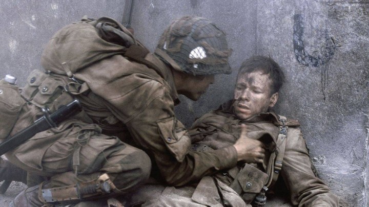 A soldier checks on his wounded comrade in Band of Brothers.