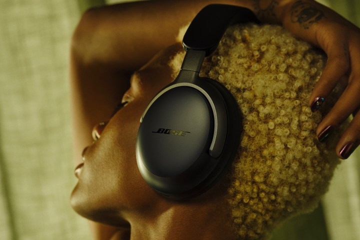 Woman cutting Bose QuietComfort Ultra Headphones in black.