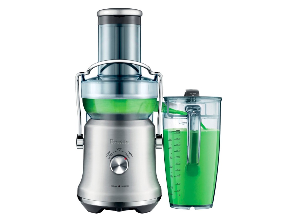 The Breville Juice Fountain Cold Plus juicer and a jug of green juice against a white background.