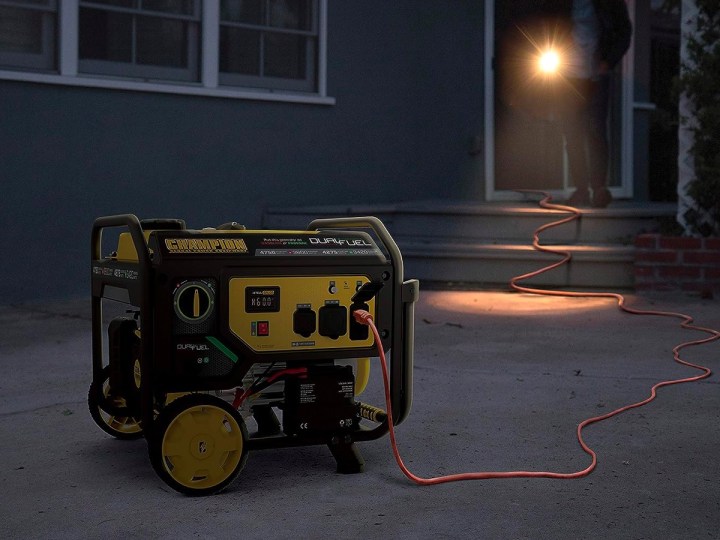 The Champion Power Equipment Dual Fuel Portable Generator provides power to a home after dark.