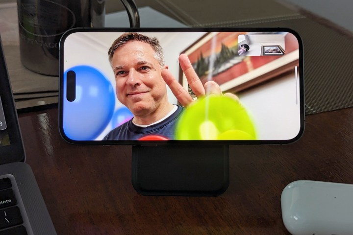 iPhone on stand in FaceTime call with balloon gesture.