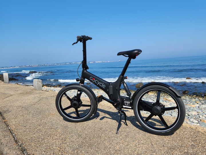 GoCycle G4 parked on the sidewalk at Long Sands Beach in York, Maine, with the ocean in the background.
