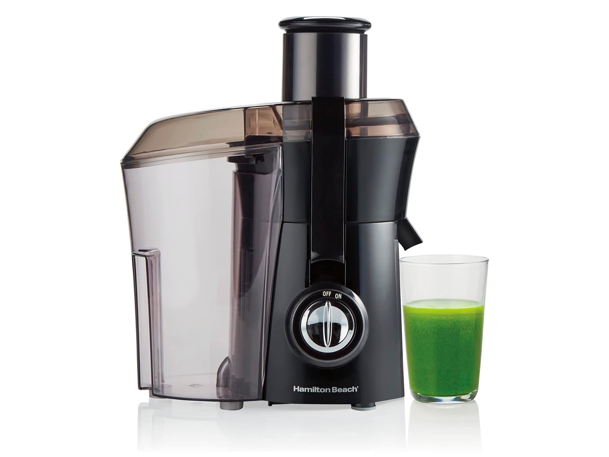 The Hamilton Beach centrifugal juicer and a glass of green juice against a white background.