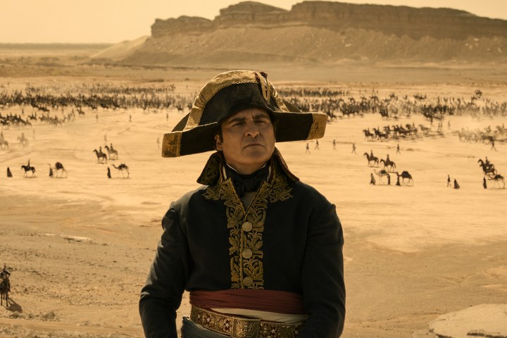 Joaquin Phoenix sits near a battlefield in Napoleon.