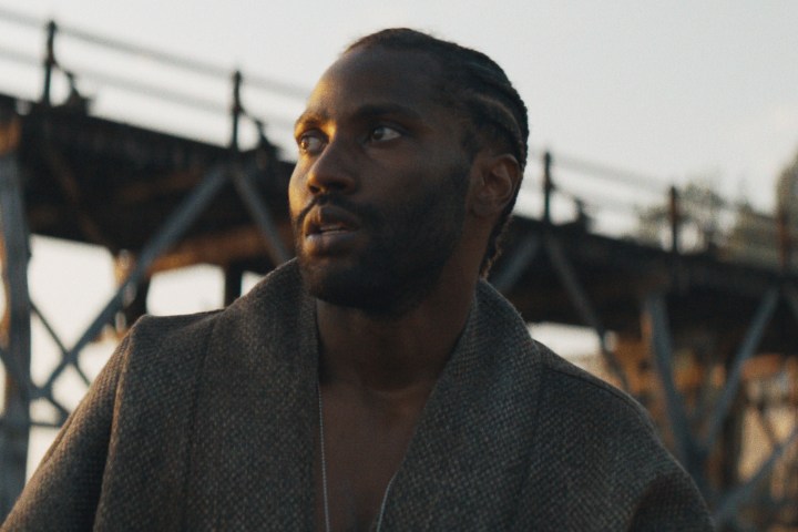 John David Washington stands by a bridge in The Creator.