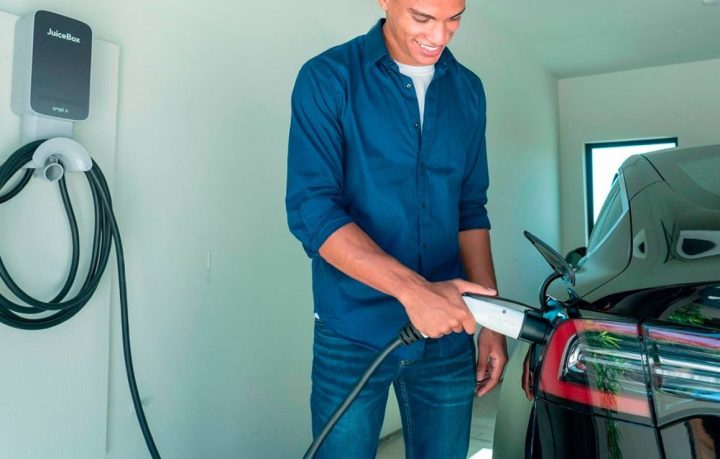 A man charges his vehicle in a garage with the Juicebox 48-amp EV charger.