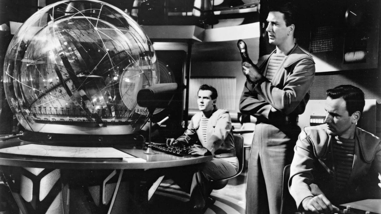 Leslie Nielse como John J. Adams con otros dos dentro de una nave espacial en Forbidden Planet de 1956.