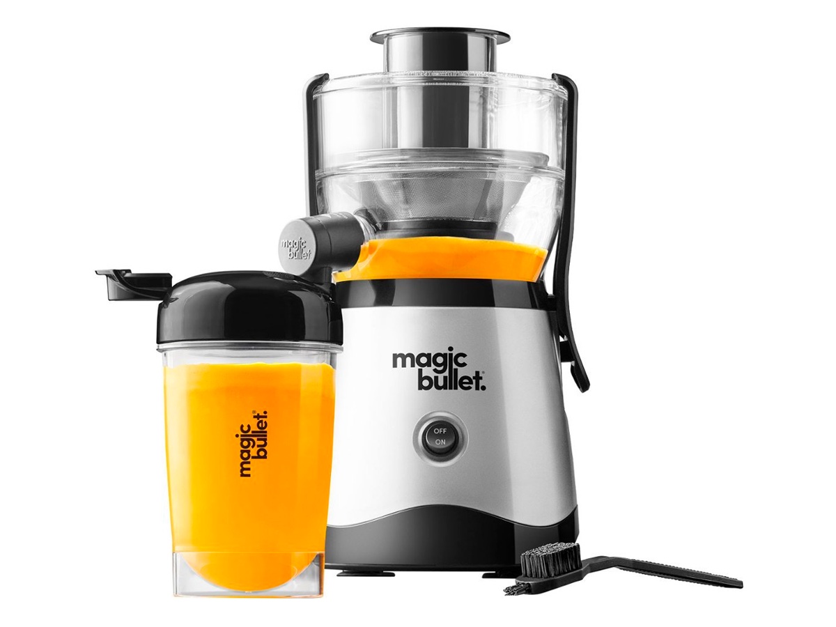 The Magic Bullet compact juicer and a glass of juice against a white background.