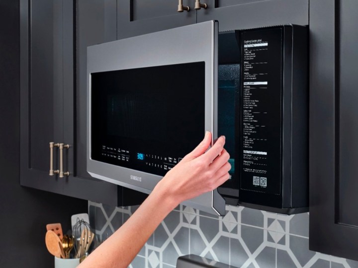 Opening the Samsung 2.1 cu. ft. over-the-range microwave in a kitchen.