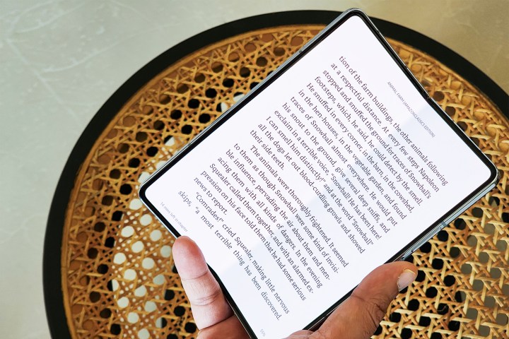Чтение из приложения Kindle на Galaxy Z Fold 5, удерживаемого в одной руке.