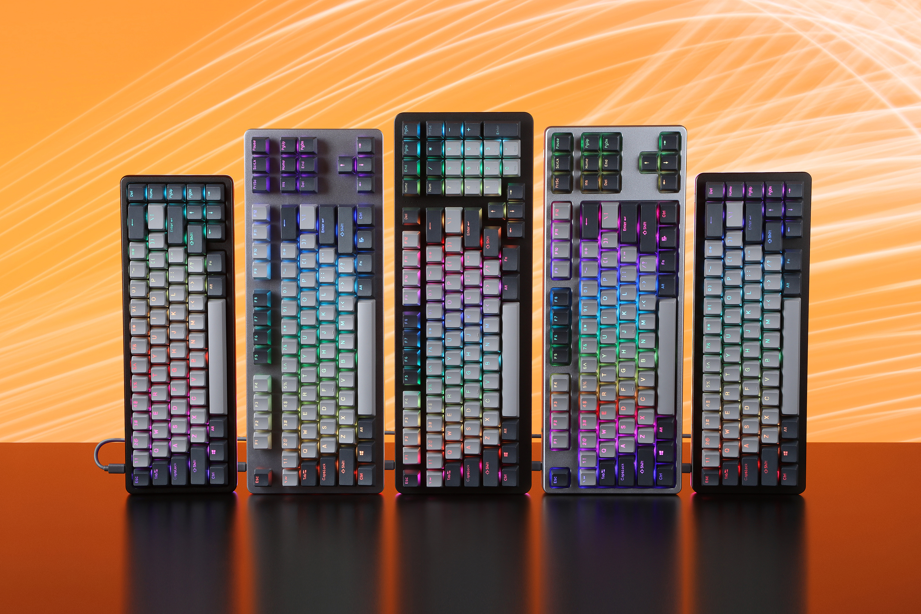Five Drop keyboards stand next to each other over an orange background.