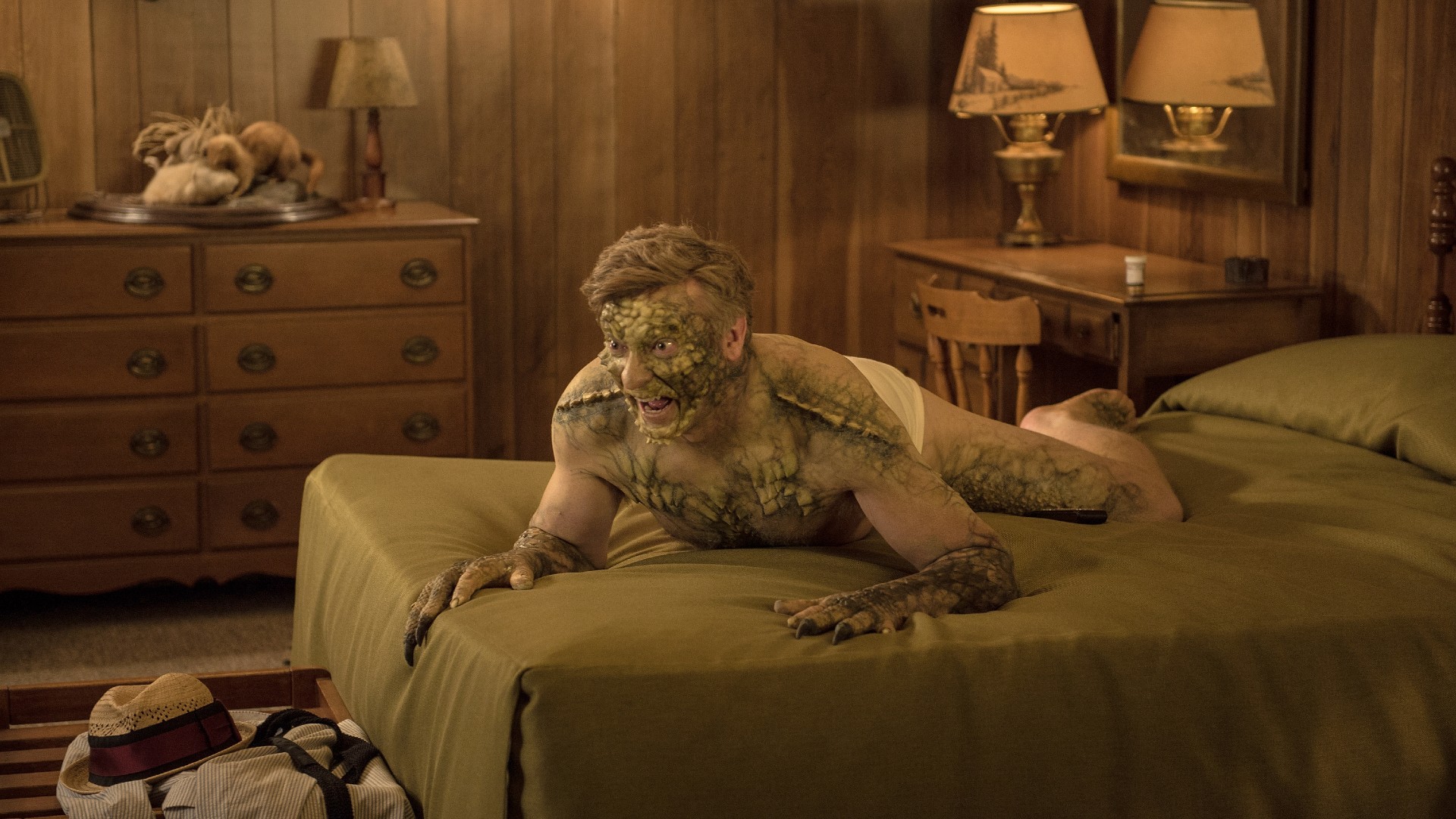 Rhys Darby turns into a Lizard Man on a bed