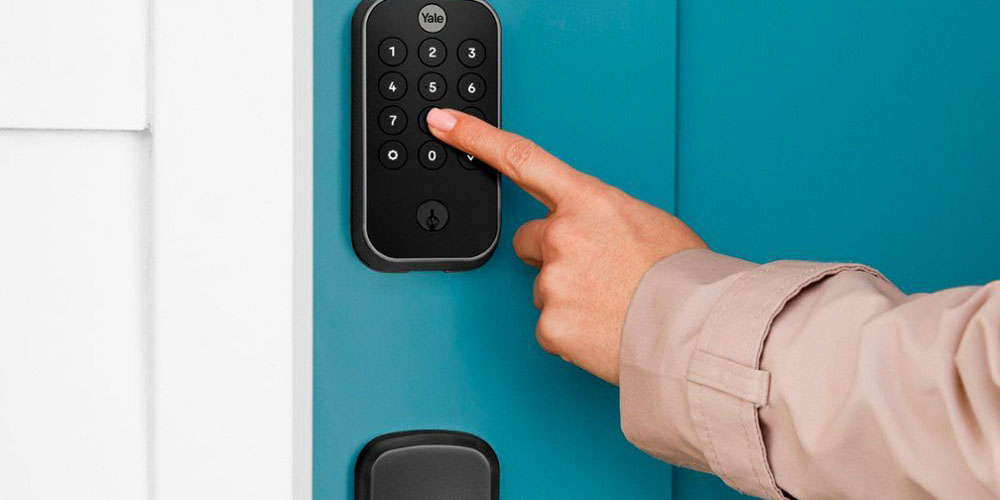 The Yale Assure Lock 2 Smart Lock Deadbolt keypad being used by someone.