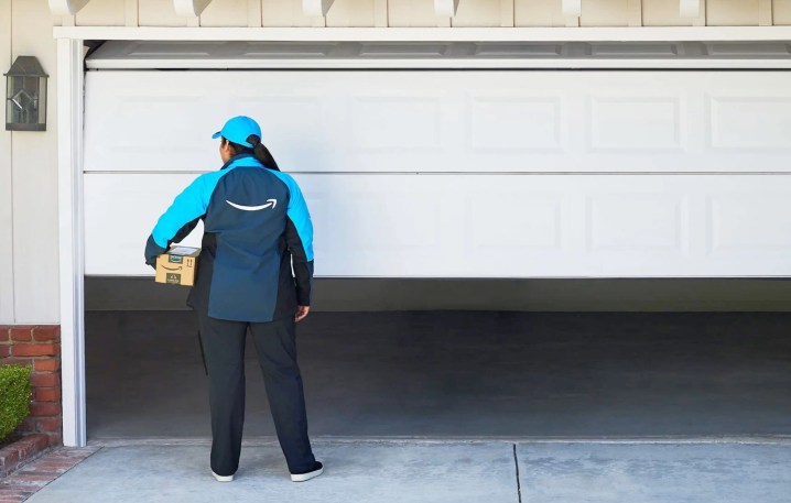 An Amazon worker delivering a package to a garage.