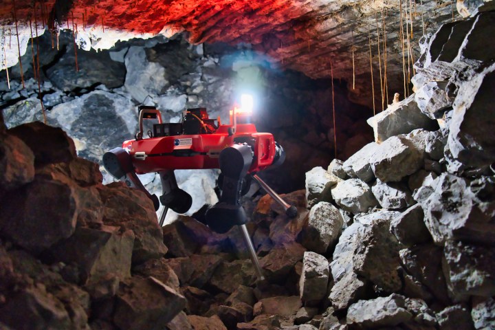 Un robot de recherche sur pattes explore une grotte.