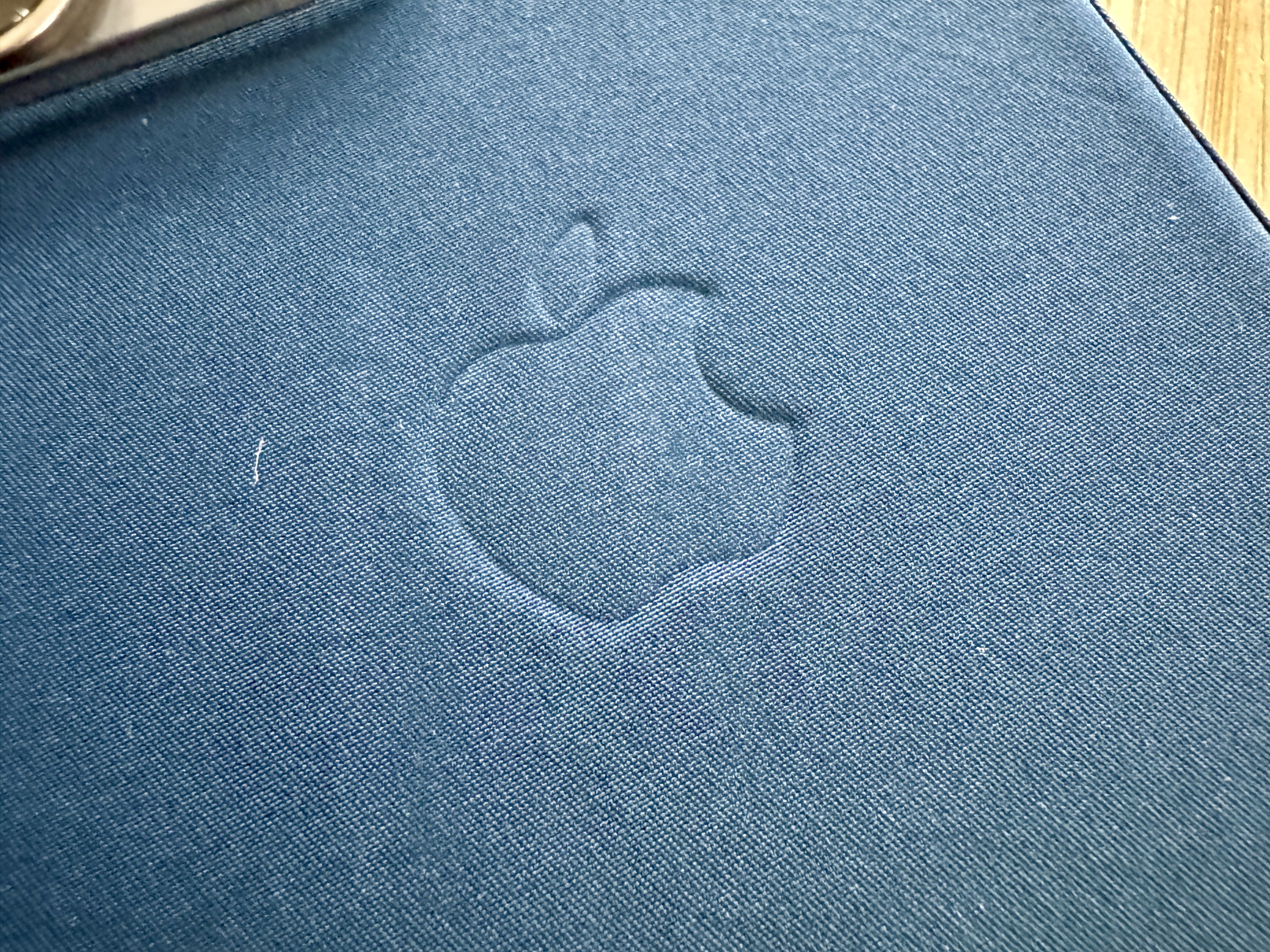 Macro of FineWoven case in Pacific Blue showing scratches and lint.