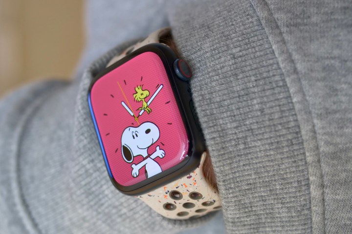 ऐप्पल वॉच सीरीज़ 9 पहनने वाला एक व्यक्ति, स्नूपी घड़ी का चेहरा दिखा रहा है