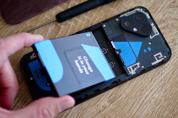 A person putting the battery inside the Fairphone 5.