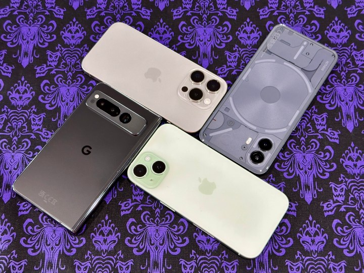 Clockwise from top: natural titanium iPhone 15 Pro, Nothing Phone 2, green iPhone 15, and Obsidian Black Google Pixel Fold.