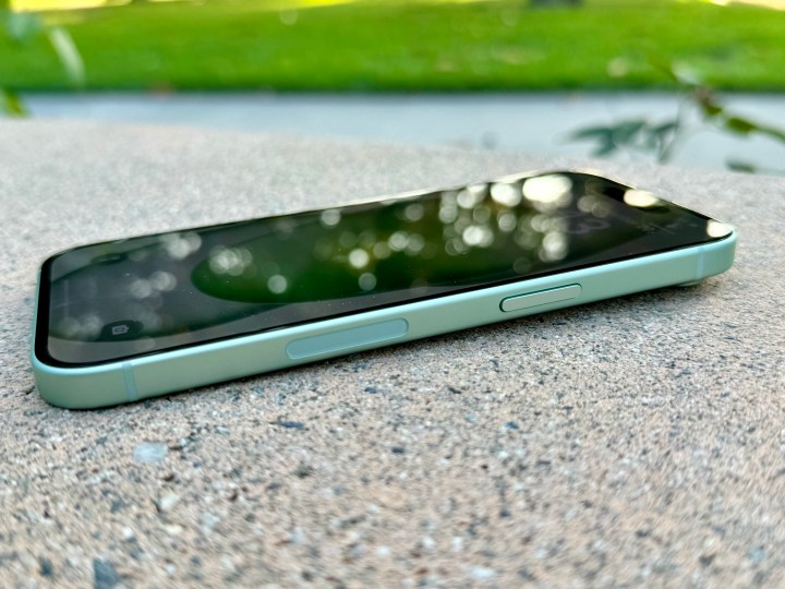 Vista laterale di un iPhone 15 verde che mostra il pulsante laterale.