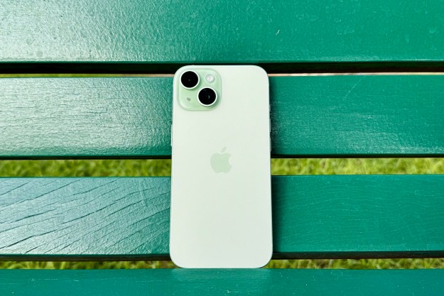 A green iPhone 15 on a green bench.