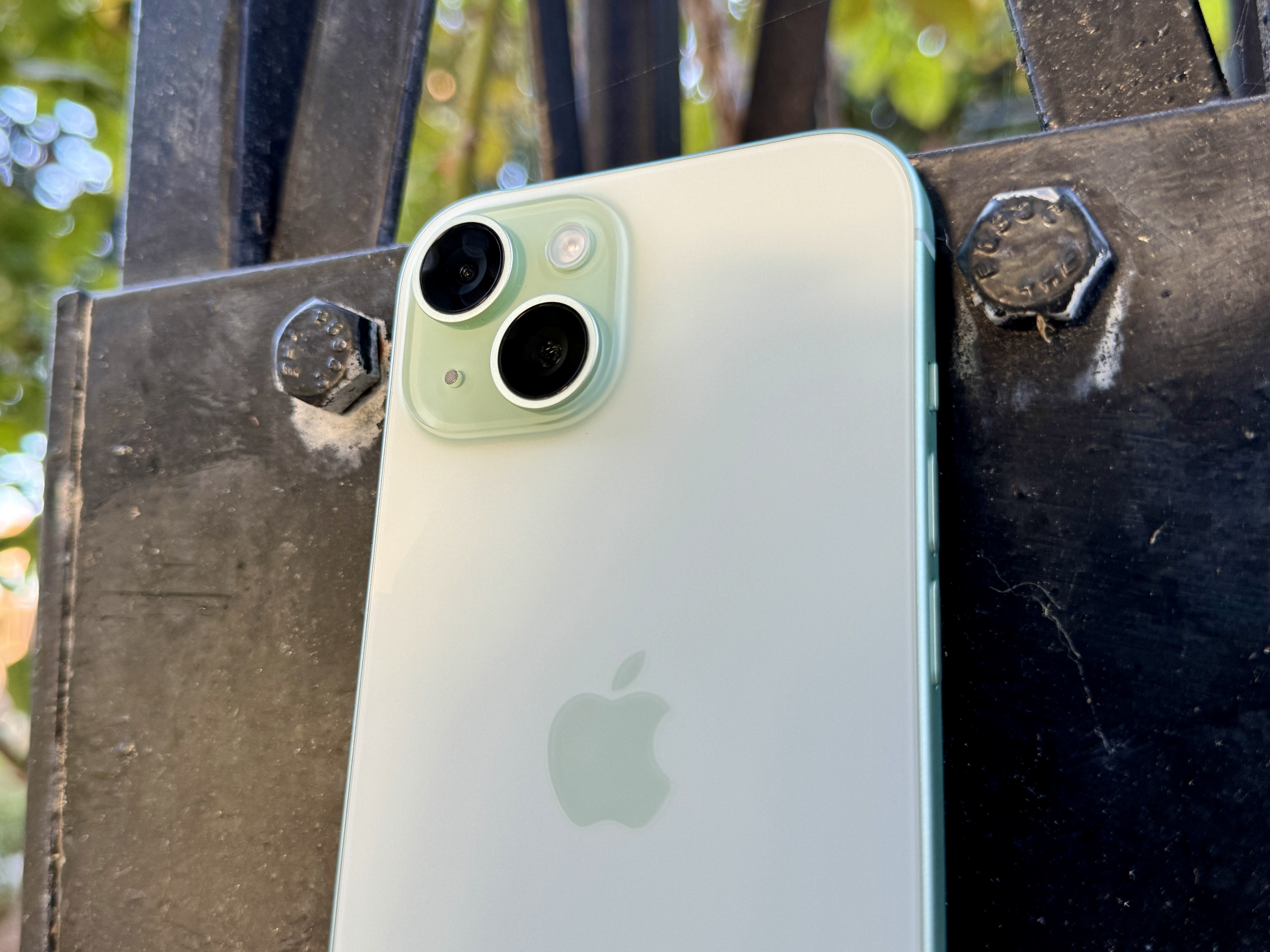Ein grünes iPhone 15 mit Kamera und mattierter Glasrückseite.