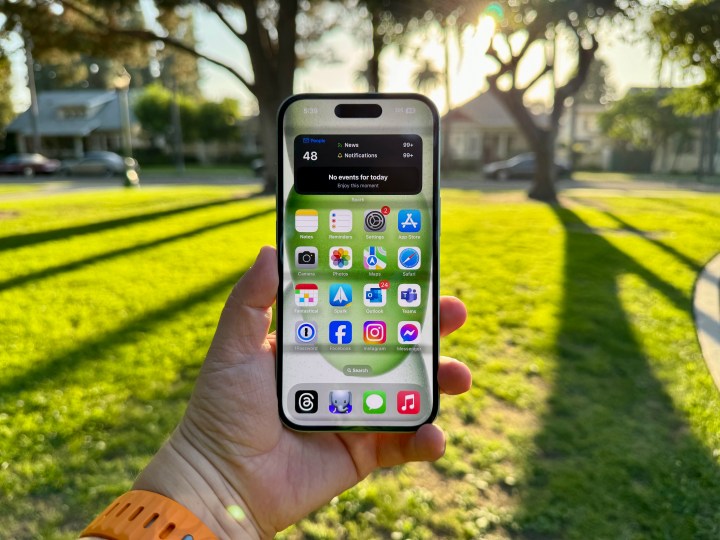 Un iPhone 15 verde en la mano que muestra la pantalla de inicio.