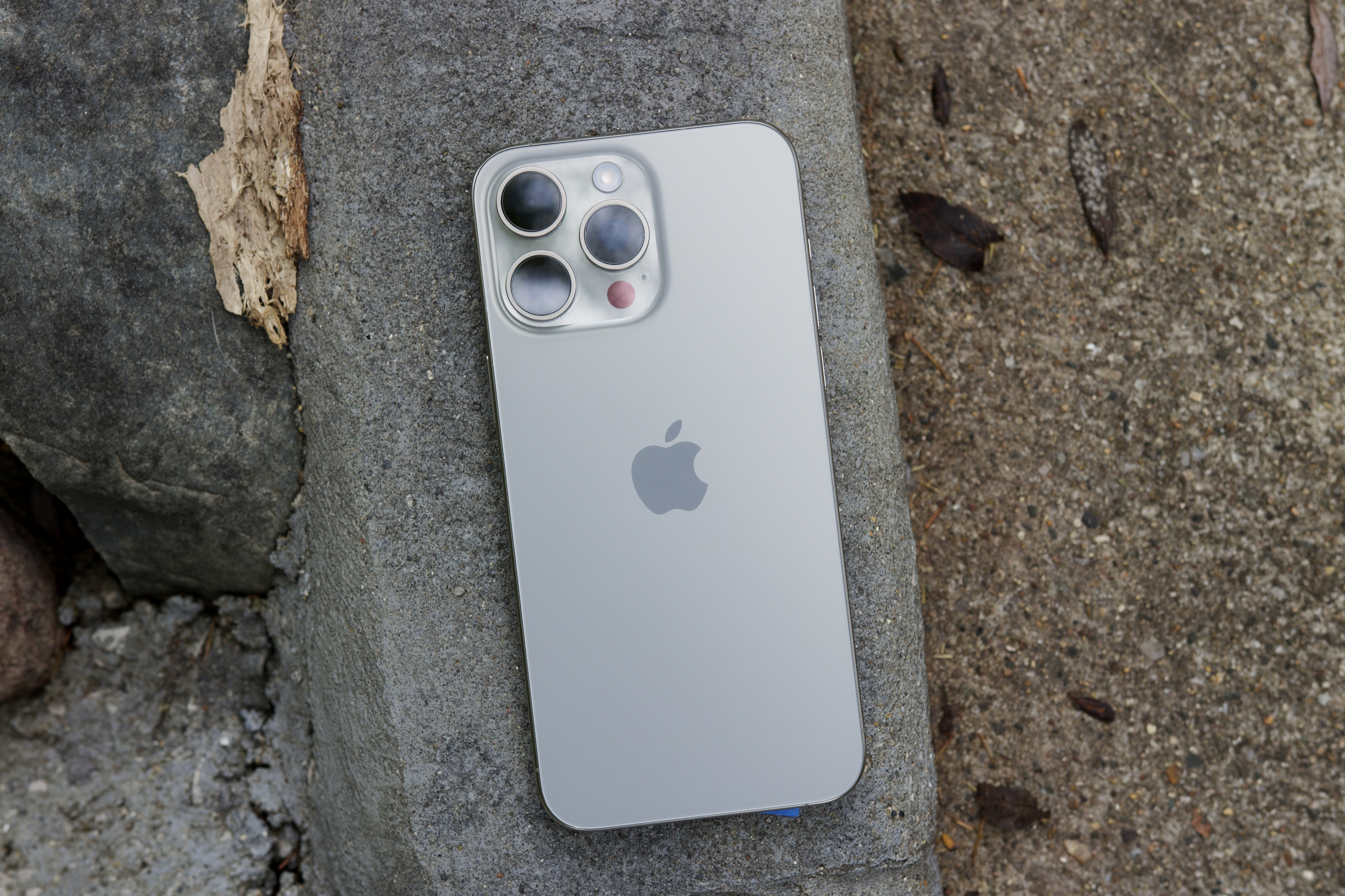 공원 밖에 누워 있는 iPhone 15 Pro Max.