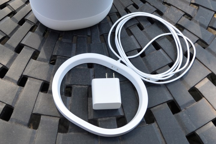 Sonos Move 2 in white seen with charging base and USB-C adapter.