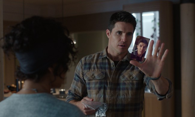 Nathan holding a virtual image up on his hand in a scene from season 3 of Upload.