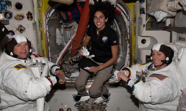 NASA astronaut Jasmin Moghbeli (center) assists astronauts Andreas Mogensen (left) from ESA (European Space Agency) and Loral O’Hara (right) from NASA as they try on their spacesuits and test the suits’ components aboard the International Space Station’s Quest airlock in preparation for an upcoming spacewalk.