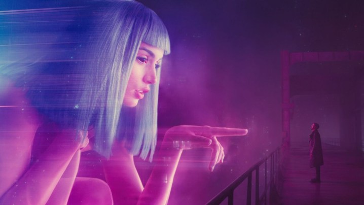 Oficial K olhando para um holograma neon em Blade Runner 2049.