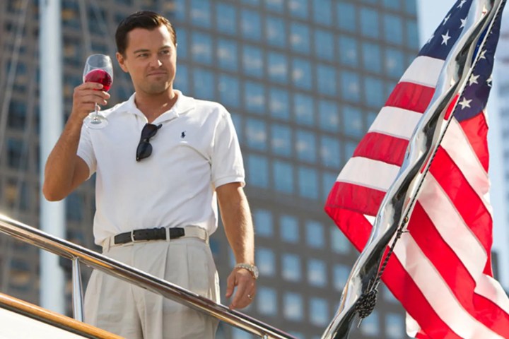 Leonardo DiCaprio stands near an American flag in The Wolf of Wall Street.
