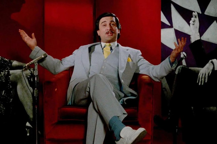 Robert De Niro se sienta en una silla roja en El rey de la comedia.